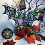 Halloween tree decorations including bats tombs and cobwebs