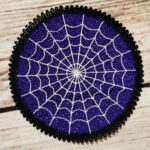 Purple lace coaster with white cobweb