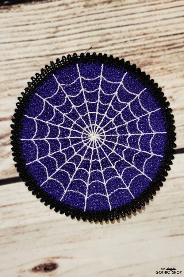Purple lace coaster with white cobweb