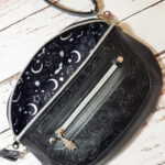 Clamshell Black Floral Vinyl Sling Crossbody Bag with Bats Lining