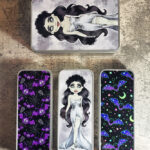 Gothic print tins with zombie bride and purple bats.